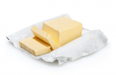 a stick of butter on its wrapper with 2 slices cut
