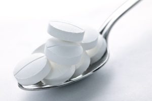 a spoon with white tablets in it.