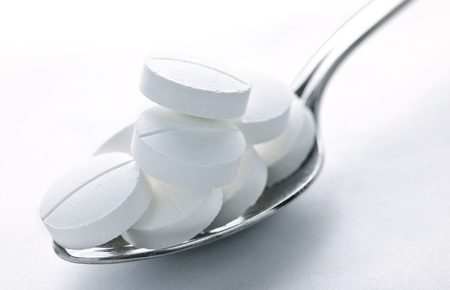 a spoon with white tablets in it.