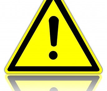 a yellow triangle sign with an explanation point inside it