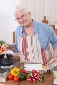 a smiling grandma stirring a pot in the kitchen