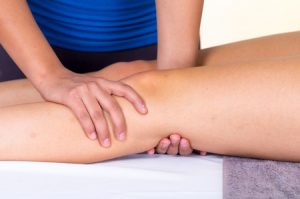a young woman lying while getting a leg massage from specialist concept of physiotherapy. 