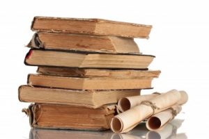 a stack of old books and a scroll