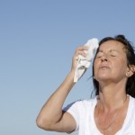 A woman wiping the sweat off her face with a white towel