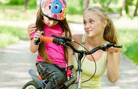 a mom talking to her daughter on her bicycle.