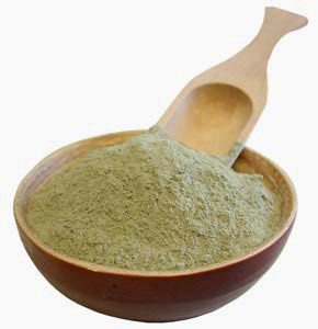 a wooden bowl with powdered French Green Clay and a wooden spoon in the bowl.a wooden