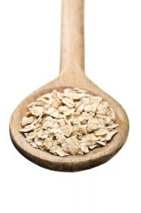 raw oatmeal in a wooden spoon