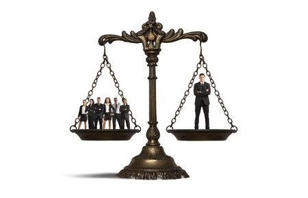 legal scales with a crowd on one side and one man on the other side