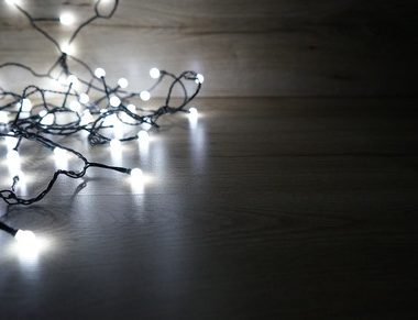 a string of Christmas lights on a dark background