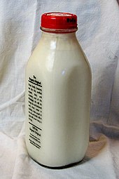 a glass bottle of milk with a red cap