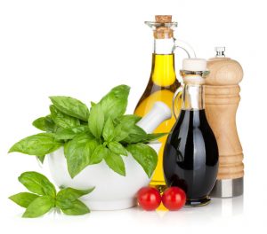 Olive oil, vinegar bottles with basil and tomatoes. Isolated on white background