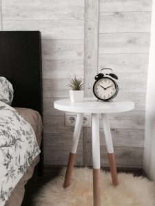 bedside table with flowers and an alarm clock