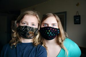 2 young girls wearing masks