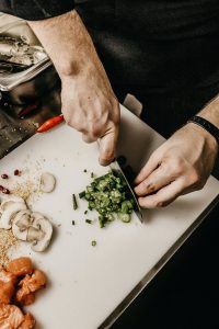 a man chopping mushrooms and green onions