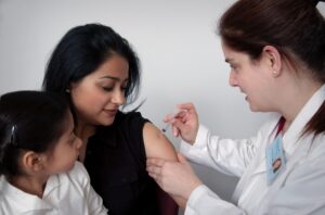 a young woman getting a vaccine in her arm