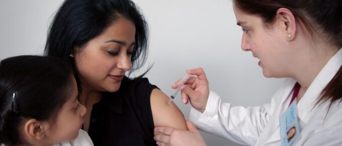 a young woman getting a vaccine in her arm