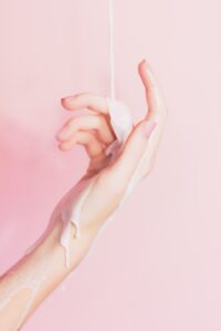 a woman's hand with lotion dripping on it