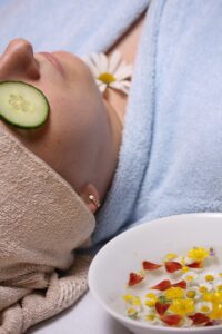 a woman at a spa with a cucumber slice over her eye