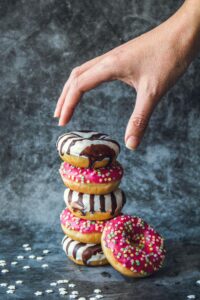 a hand reaching for a stack of donuts