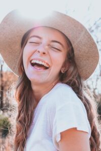 a laughing girl with a sun hat on