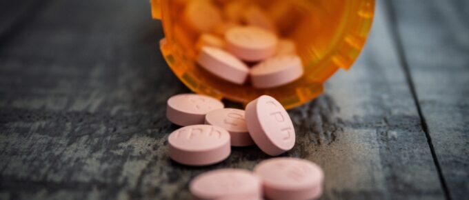 pink pills spilling out a pill bottle
